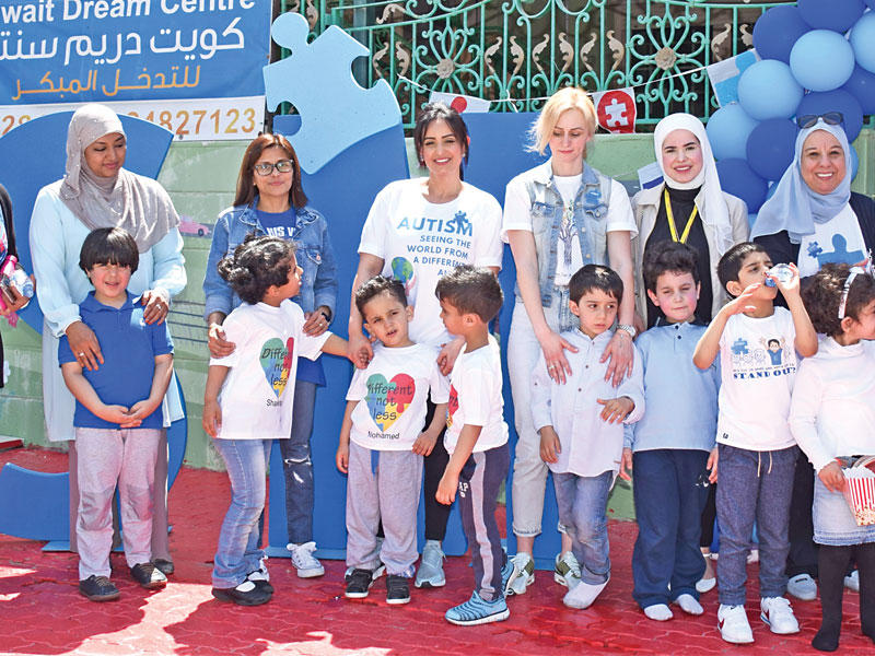 موظفو البنك مع طلاب وموظفات مركز التوحد أثناء الاحتفالية 