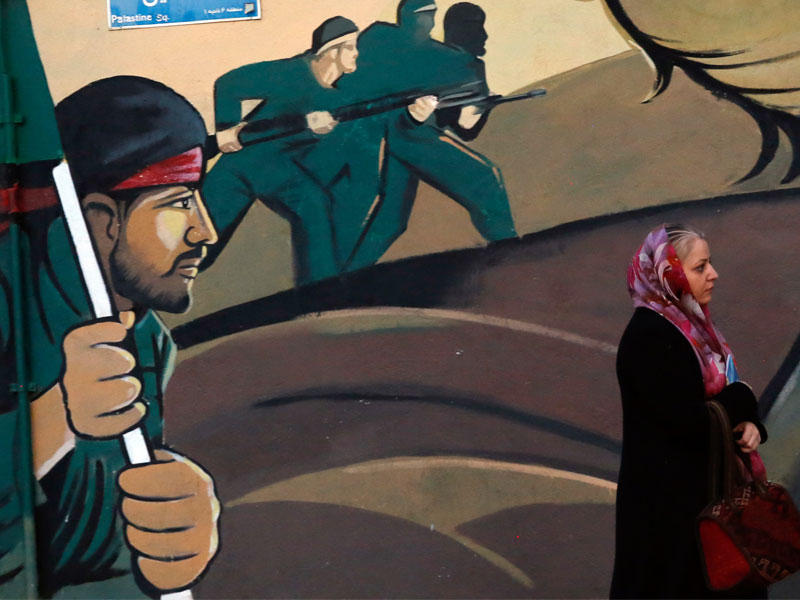 إيرانية تمر أمام جدارية للحرس الثوري في طهران أمس (أي بي أيه)n