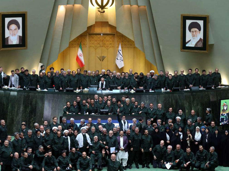نواب مجلس الشورى بصورة جماعية بعد ارتداء الزي الرسمي لـ«الحرس الثوري» بمقر البرلمان في طهران أمس (إرنا)