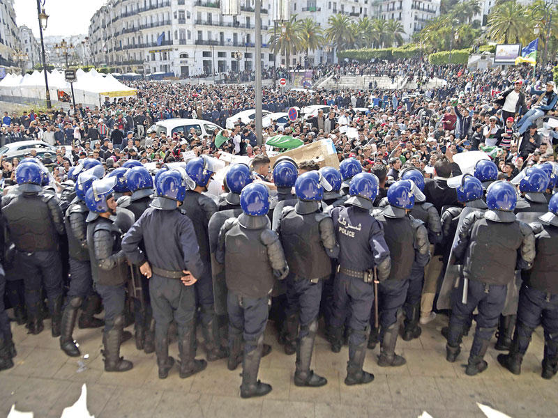 قوات الأمن تحاول منع المتظاهرين من التقدم باتجاه البرلمان الجزائري وسط العاصمة أمس t(أ ف ب)