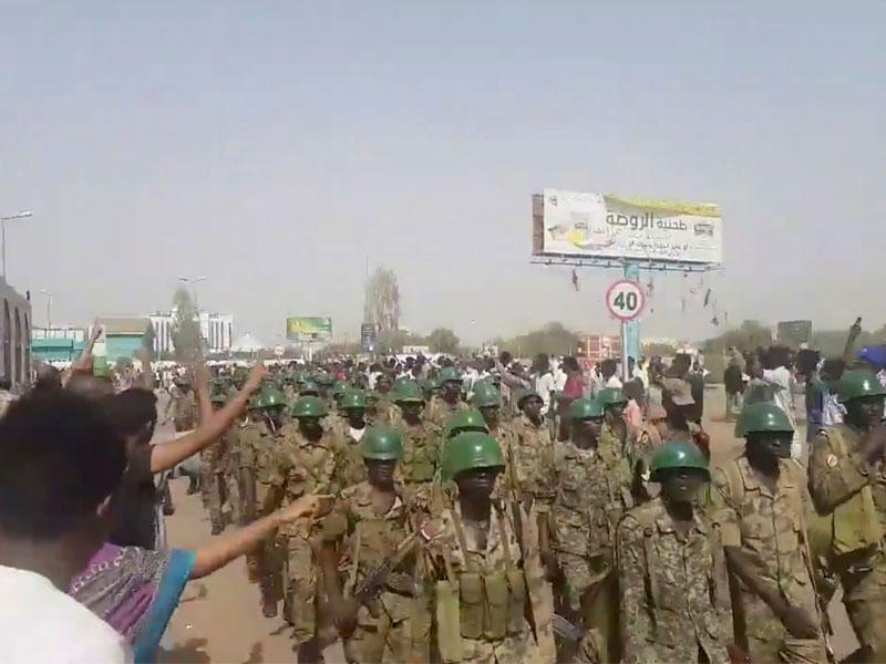 متظاهرون سودانيون يحيّون عناصر الجيش في الخرطوم أمس (رويترز)