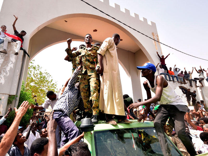 مدنيون وجنود وسط الخرطوم امس قبل إعلان الجيش «البيان رقم 1» (أ ف ب)n