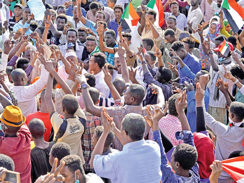 سودانيون يحتفلون بتنحي بن عوف أمام مقر قيادة الجيش في الخرطوم أمس (رويترز)