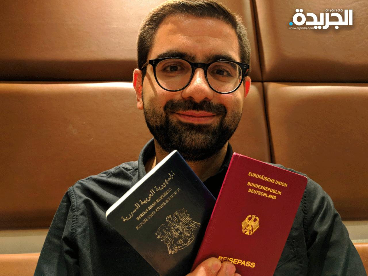 احد اللاجئين السوريين ممسكاً بجوازه الألماني
