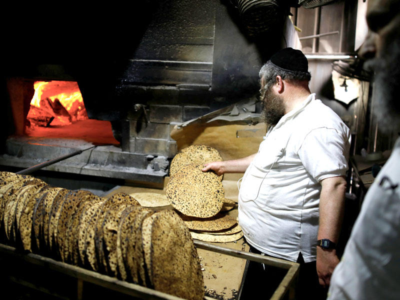 يهودي أرثوذكسي يعد خبر الماتزا الخاص بعيد الفصح أمس الأول (رويترز)