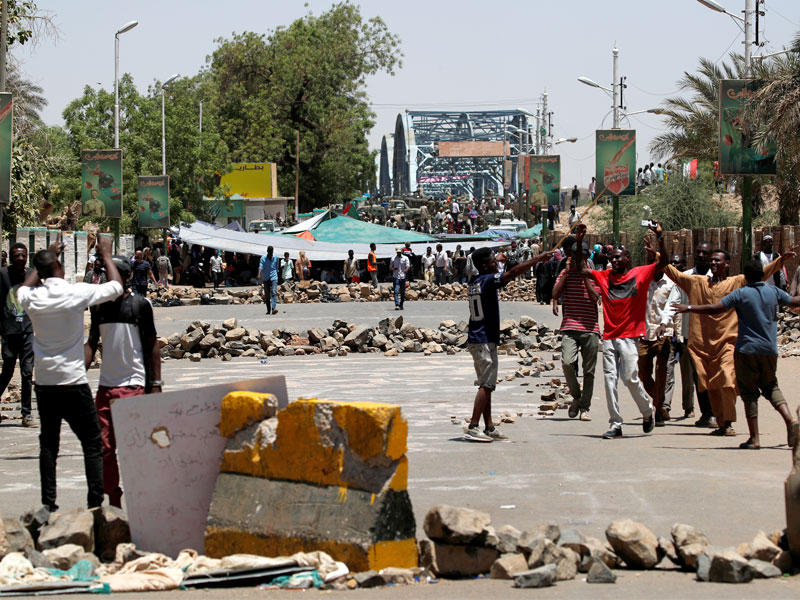 سودانيون يفتّشون متظاهرين جدداً حضروا للمشاركة في الاعتصام أمام مقر القيادة العامة بالخرطوم أمس (رويترز)