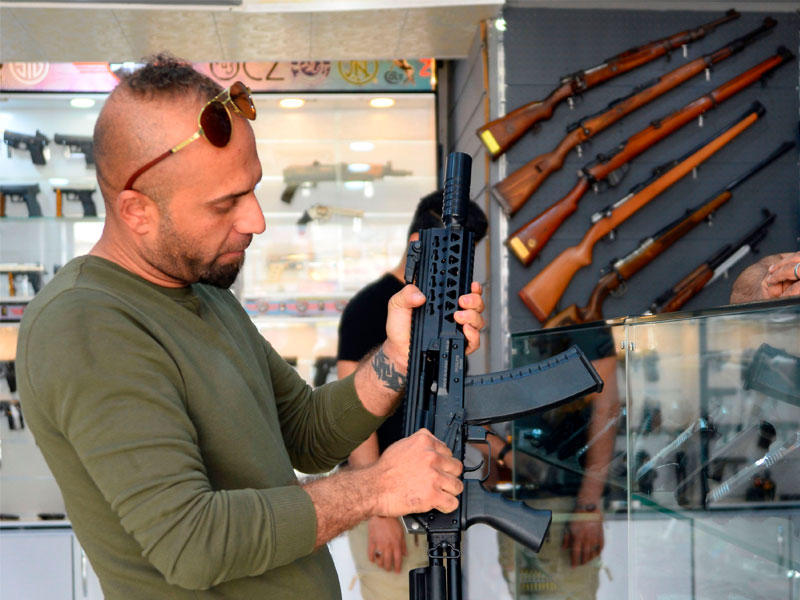 عراقي يعاين بندقية في محل لبيع السلاح بالنجف (أ ف ب) n