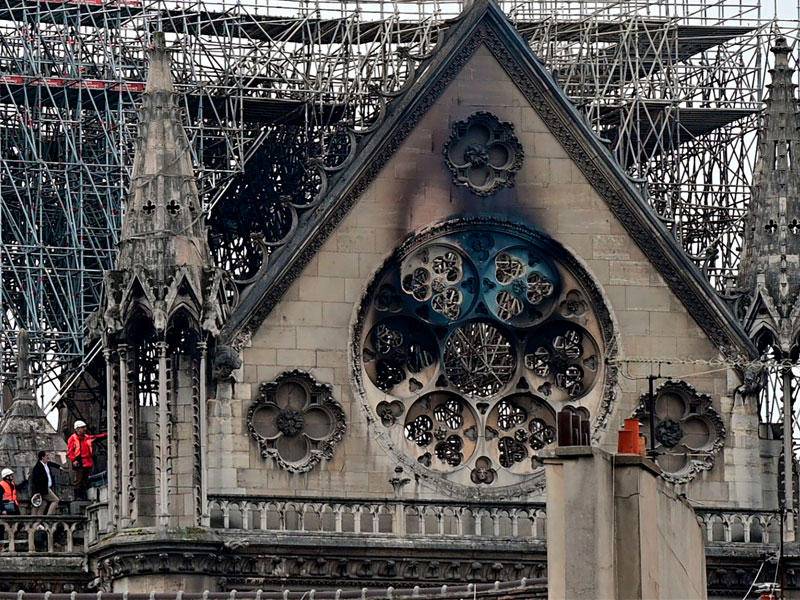 خبراء يعاينون الدمار الذي ألحقه الحريق  بسقف الكاتدرائية أمس (أ ف ب)