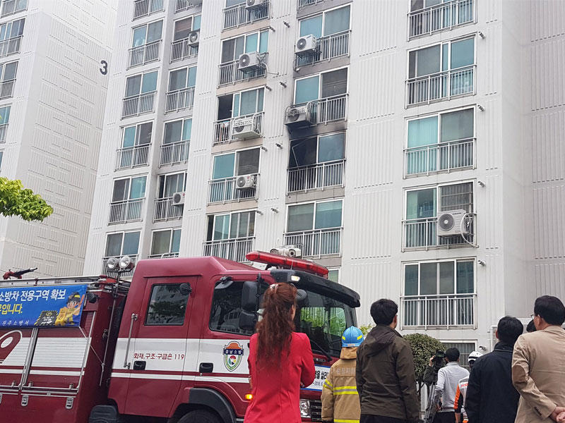 رجال الاطفاء والسكان يتجمعون خارج شقة دمرتها الحرائق في مدينة جينجو الجنوبية