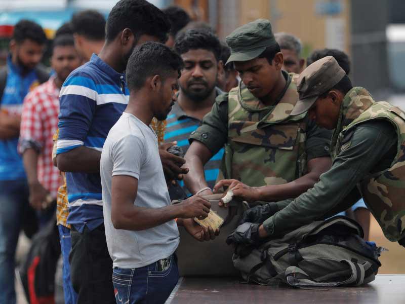 عناصر من الجيش تفتش حقائب المواطنين في منطقة كاتانكودي أمس (رويترز)