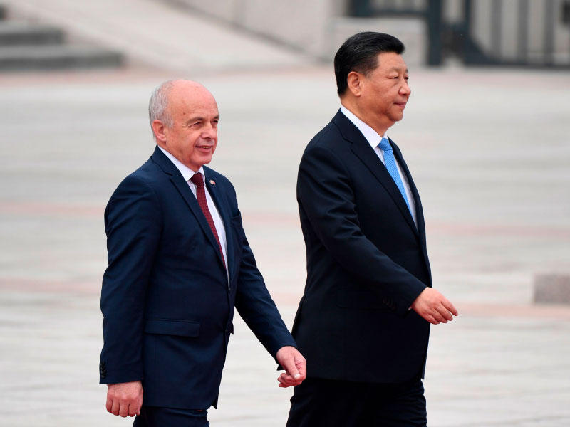 رئيس سويسرا أولي مورير والرئيس الصيني شي جين بينغ يمشيان معاً خلال حفل استقبال في قاعة الشعب الكبرى