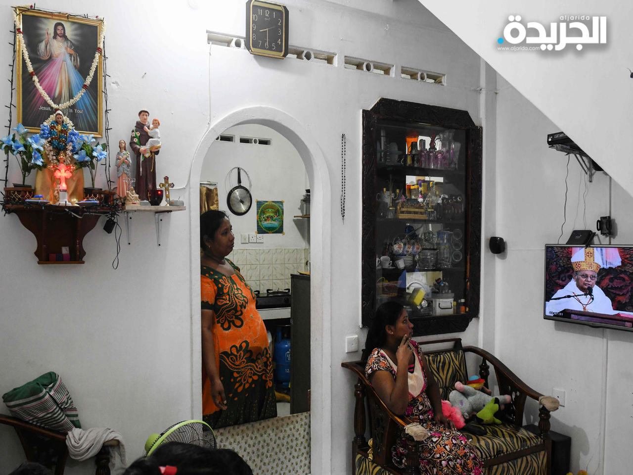 سيدتان يتابعن قداس الأحد عبر شاشة التلفاز