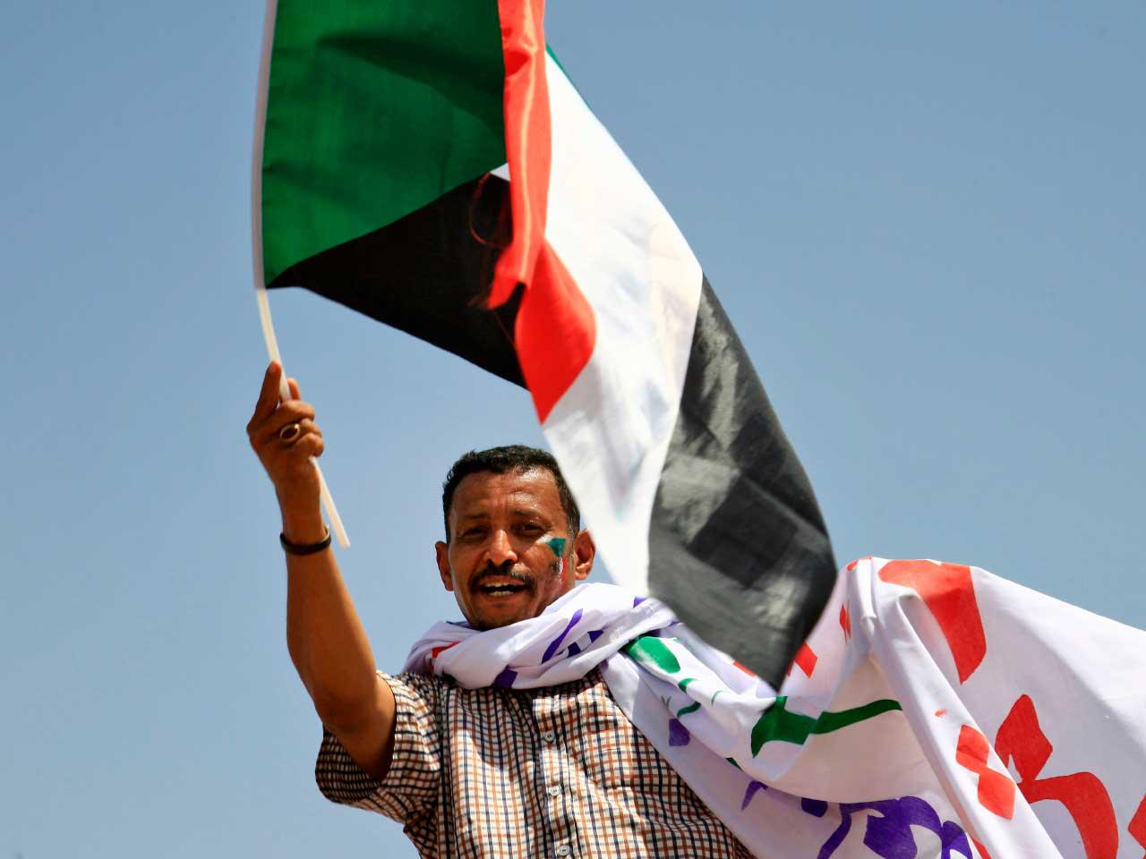 أحد مؤيدي المعارضة السودانية يلوح بعلم وطني خلال اعتصام خارج مقر الجيش في الخرطوم