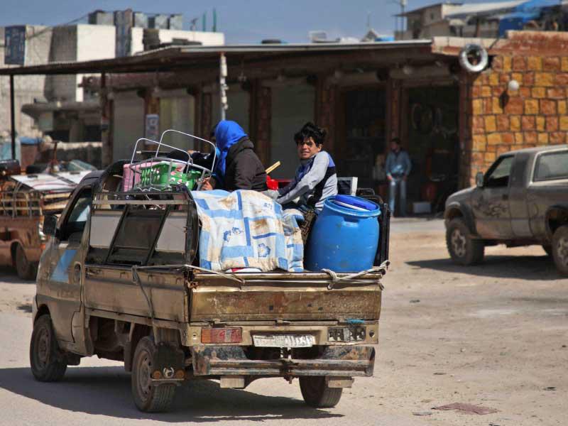 السوريون النازحون يتجهون نحو منطقة بالقرب من مخيم للنازحين في قرية عتمة ، في محافظة إدلب