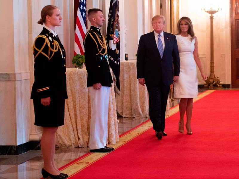 ترامب وزوجته ميلانيا في طريقهما للاحتفال بـ «الأم العسكرية» في البيت الأبيض أمس الأول  (أ ف ب) 