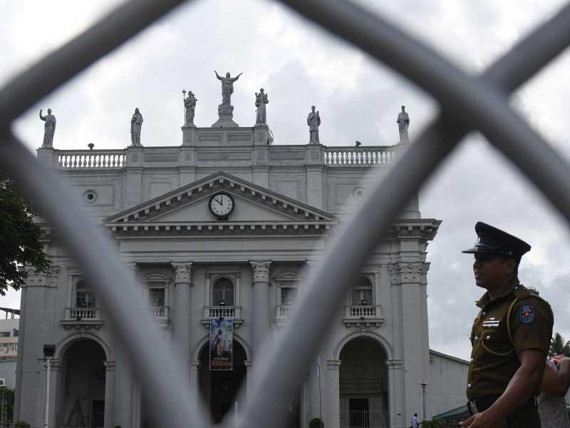 ضابط شرطة سريلانكي على حراسة في كاتدرائية سانت لوسيا أثناء قداس جماعي