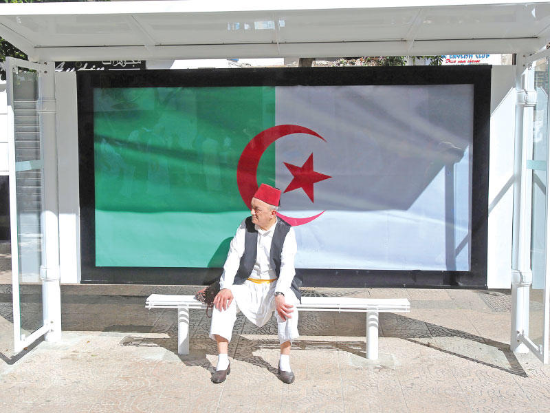 جزائري ينتظر حافلة بالعاصمة الجزائرية            (رويترز)