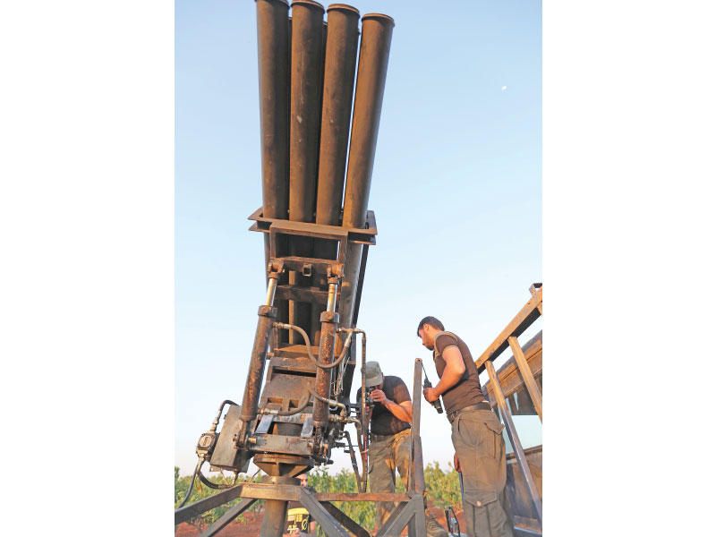 مقاتلان من «النصرة» يجهزان لإطلاق الصواريخ على مواقع النظام في حماة أمس الأول (أ ف ب)