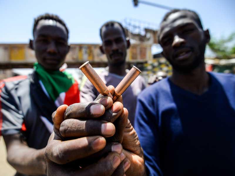 رجال سودانيون يحملون أغلفة الرصاص في الاحتجاج خارج مقر الجيش في العاصمة الخرطوم
