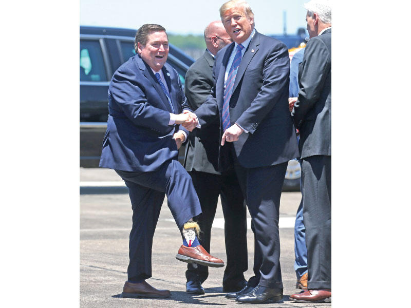  حاكم لويزيانا يكشف لترامب لدى وصوله إلى مطار الولاية عن جوارب عليها رسم الرئيس             (رويترز) 