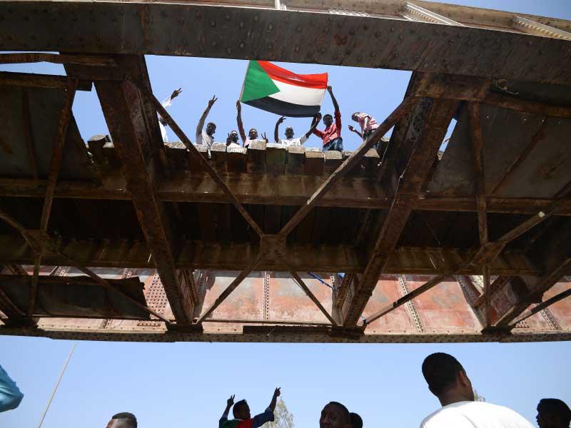 المتظاهرون السودانيين يلوحون بعلم وطني بالقرب من المقر العسكري في العاصمة الخرطوم