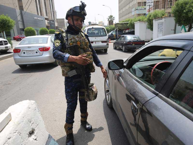 أحد أفراد قوات الشرطة الفيدرالية العراقية يقف حرسًا عند نقطة تفتيش في حي الكرادة ببغداد