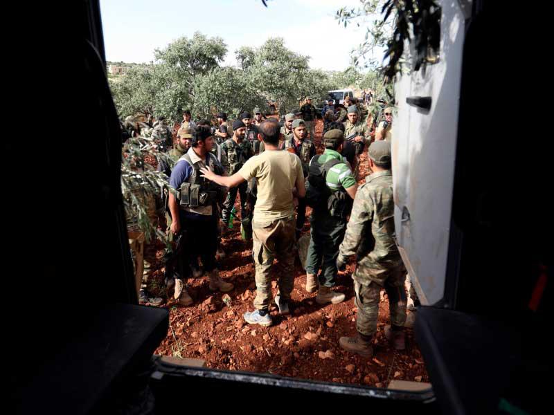 متمردون سوريون يتجمعون في حقل في الريف الشمالي لمحافظة حماة