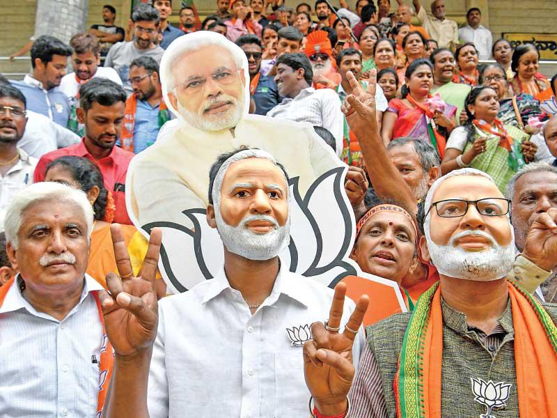 هنود يرتدون أقنعة تمثل وجه مودي خلال احتفالات في بنغالور أمس           (أ ف ب)