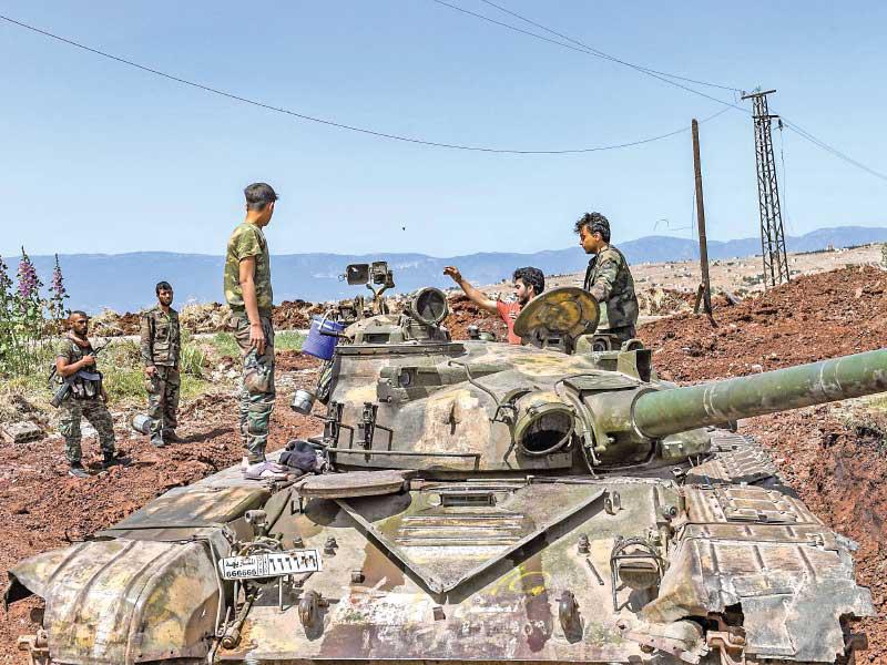 جنود سوريون فوق دبابة بقرية الجابرية في ريف حماة أمس الأول (أ ف ب)