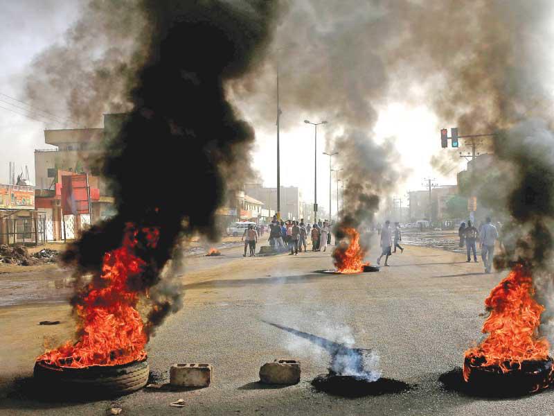 متظاهرون سودانيون يشعلون إطارات في أحد شوارع الخرطوم أمس          (رويترز)