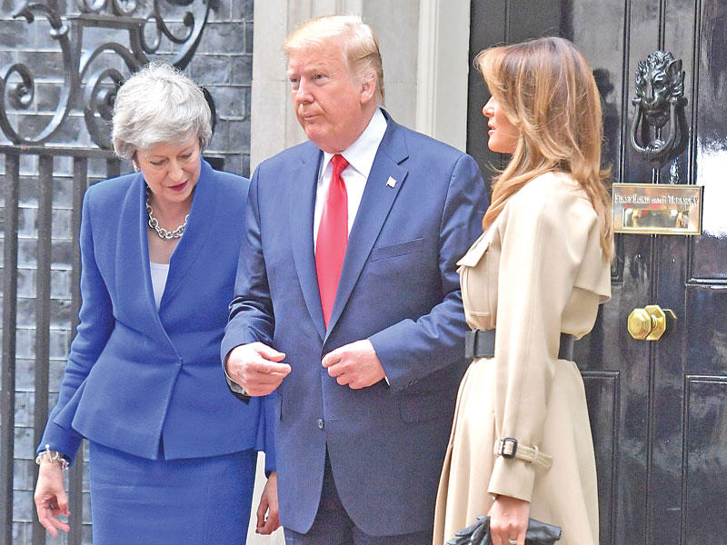 ترامب متوسطاً ماي وميلانيا أمام «10 داونينغ» أمس (أ ف ب)