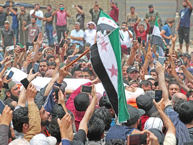 معارضون سوريون خلال تشييع الساروت بإدلب أمس (أ ف ب)