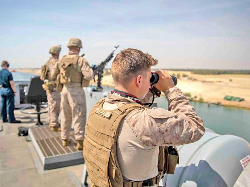 جنود أميركيون على متن بارجة «أرلينغتون» خلال عبورها قناة السويس أمس الأول 