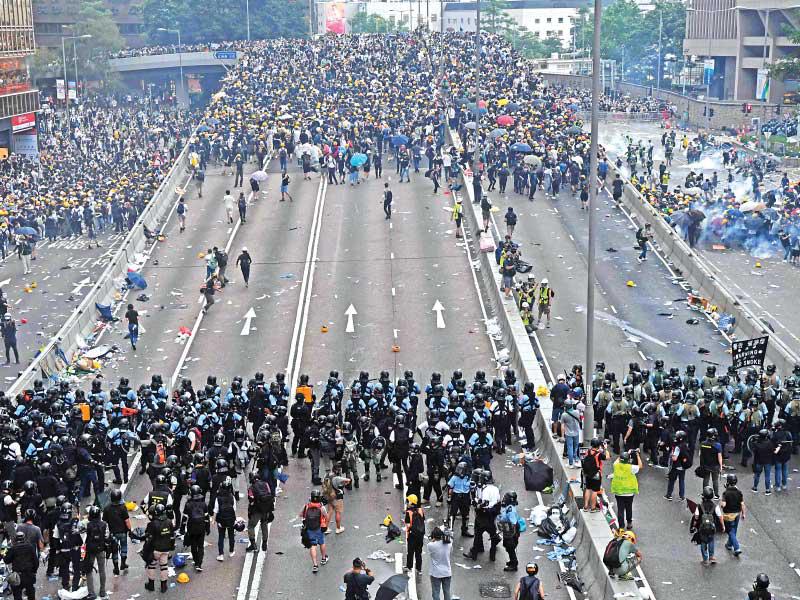 الشرطة تغلق الطريق أمام المتظاهرين لمنعهم من اقتحام البرلمان في هونغ كونغ أمسt(أ ف ب)