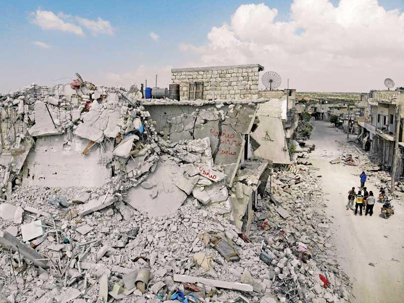 سوريون في شارع دمره قصف بلدة إحسم بإدلب أمسt (أ ف ب)