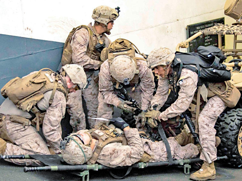 جنود من المارينز يسعفون زميلهم خلال تدريبات على متن السفينة الحربية «كيرسارج» بمنطقة عمليات الأسطول الخامس 