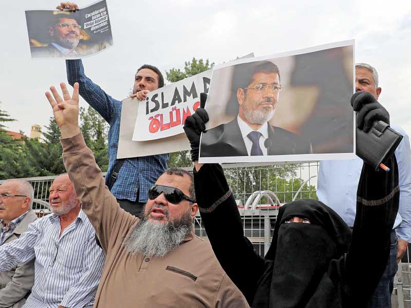 مصريون وأتراك وعرب يحملون صور مرسي أمام السفارة المصرية في أنقرة أمسt(أ ف ب)