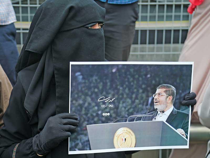 امرأة تحمل صورة مرسي أمام السفارة المصرية في أنقرة أمس tt            (إي بي ايه)