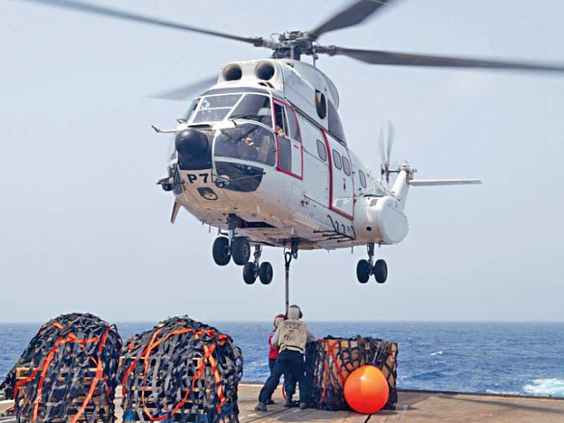 مروحية تنزل مواد عسكرية على متن سفينة حربية أميركية في منطقة عمليات الأسطول الخامس 