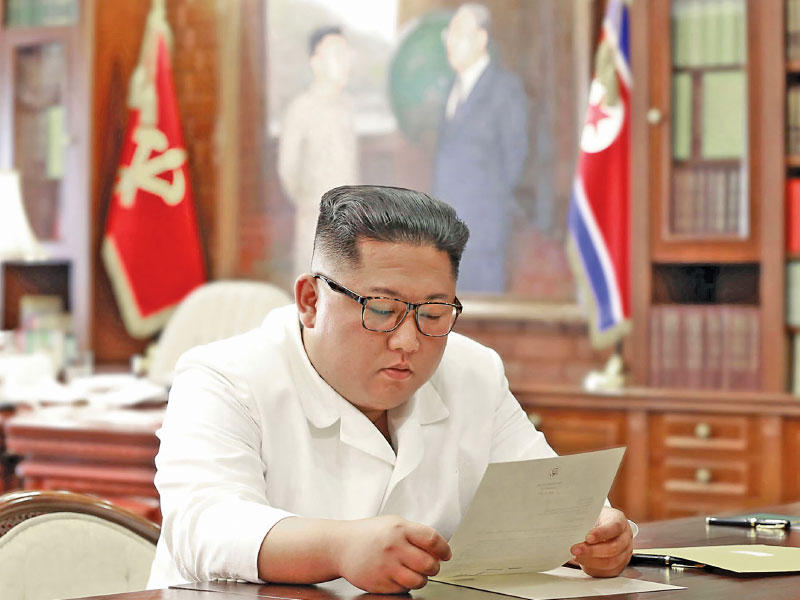 الزعيم الكوري الشمالي يقرأ رسالة ترامب أمس (أ ف ب)