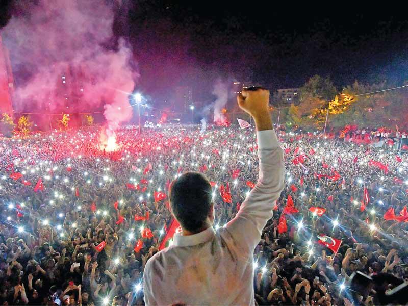 إمام أوغلو يحيي أنصاره الذين يحتفلون بفوزه بالانتخابات مساء أمس الأول في إسطنبول (أ ف ب)