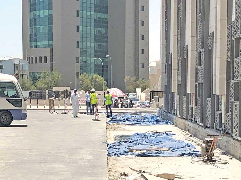 عمال الشركة المسؤولة عن تطوير المجمع تحت أشعة الشمس خلال ساعات الحظر