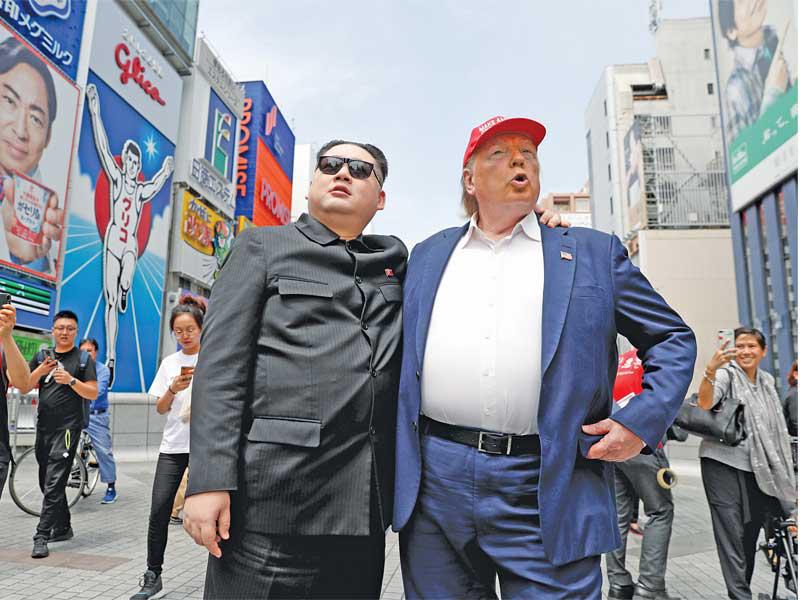 ممثلان يجسدان ترامب وزعيم كوريا الشمالية كيم جونغ أون في أوساكا حيث تعقد قمة مجموعة العشرين وسط عودة الحديث عن قمة ثالثة قد تعقد بين الرجلين (رويترز)