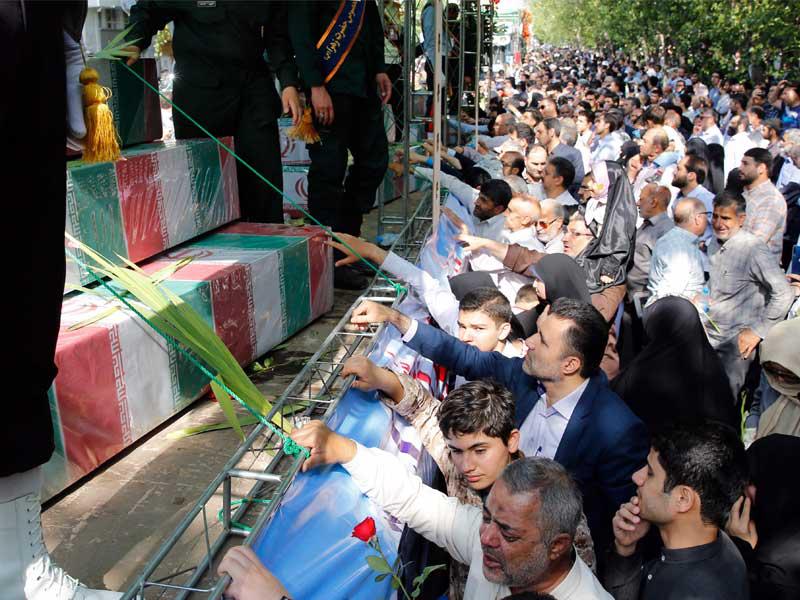 إيرانيون خلال مراسم تشييع رفات جنود سقطوا خلال الحرب العراقية الإيرانية في طهران أمس  (إرنا)