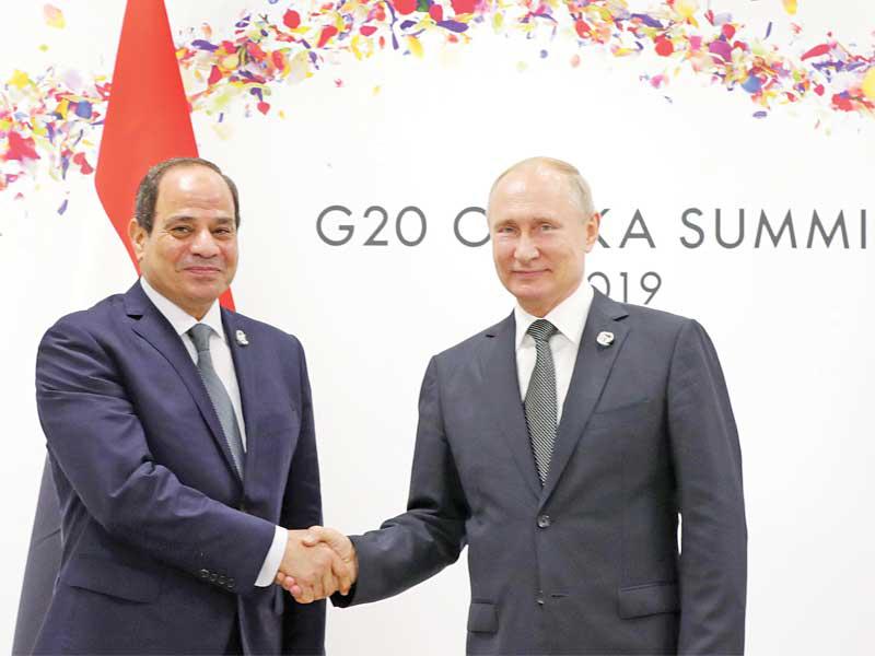 مصافحة بين الرئيسين السيسي وبوتين في أوساكا باليابان أمس (اي بي ايه)