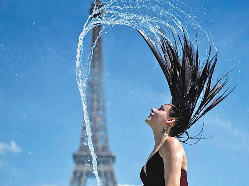 فرنسية تلجأ لماء نافورة أيفيل لتخفيف حرارة الجو  (أ ف ب) 