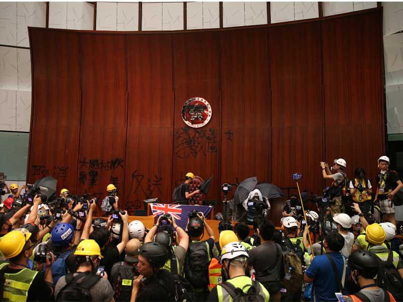 ذكرى إعادة المستعمَرة البريطانية السابقة للصين عام 1997 وهم يحملون المظلات (كما في الصورة)