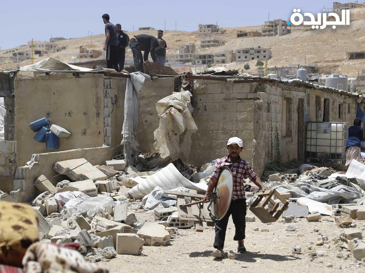 لاجئ سوري يزيل ممتلكاته من كوخ قبل هدمها في مخيم للاجئين في بلدة عرسال في شمال شرق لبنان ،