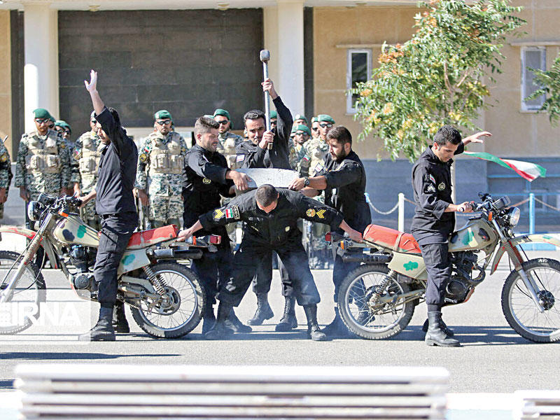 عسكري إيراني يكسر حجراً على ظهر زميله خلال استعراض لقوات الأمن في شيراز أمس (ارنا) 