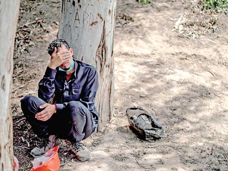 عامل اغاثة متأثراً لدى العثور على مقبرة جماعية في الرقة قبل أشهر. وأمس، عثر على رفات 200 شخص من ضحايا «داعش» في موقع قريب (أ ف ب)